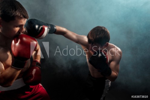 Picture of Two professional boxer boxing on black smoky background